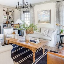 The Cottage Journal Southern Cottage 2022 living room with white furniture, navy rug, and brown table