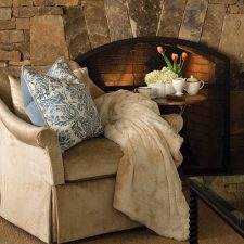 chair with blanket next to fireplace